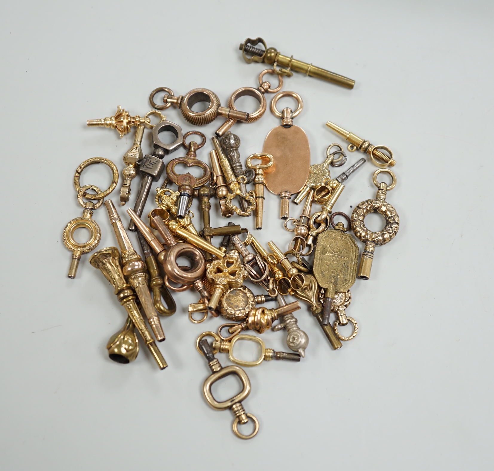 Forty assorted mainly 19th century yellow metal, yellow metal overlaid and base metal small watch keys, including trade insignia and keys for turning in one direction, largest 52mm, together with a limited edition copy,